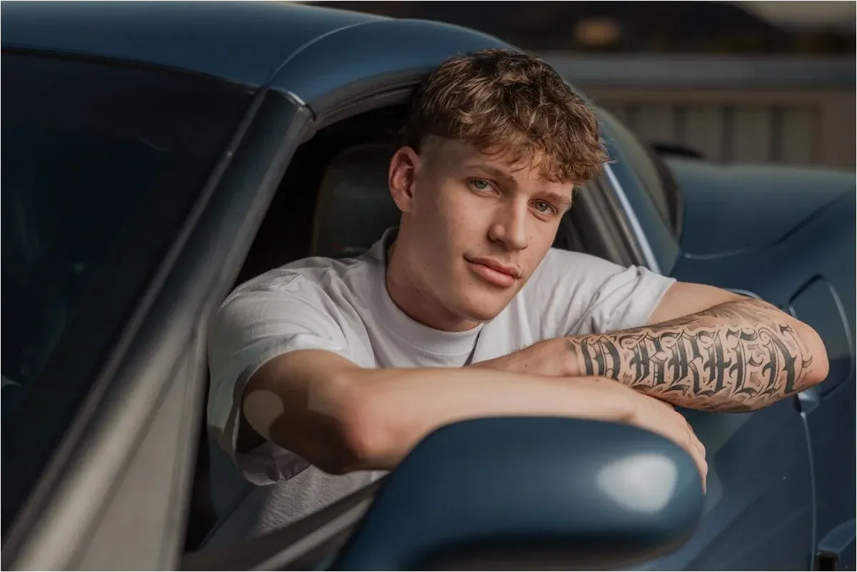 Senior guy leaning out of a classic car window