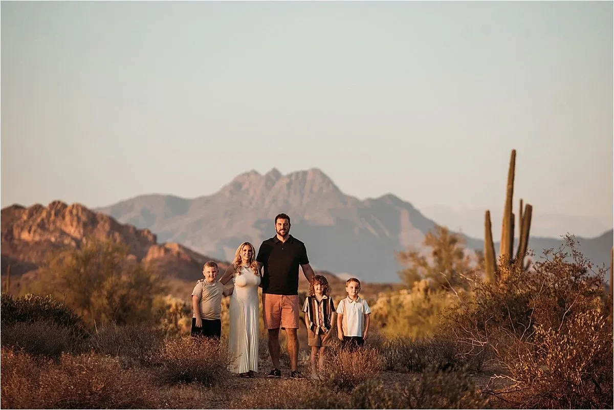 Family with saguaros and mountains at dusk