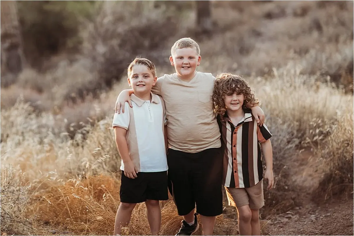 Three brothers laughing together in the desert