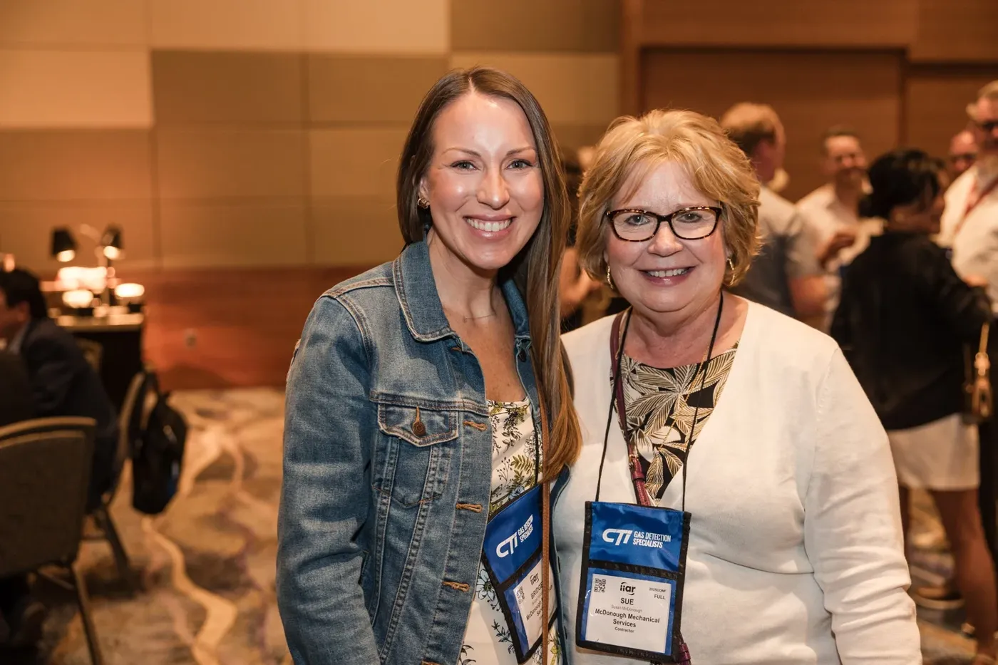 Two conference attendees smiling at a networking reception