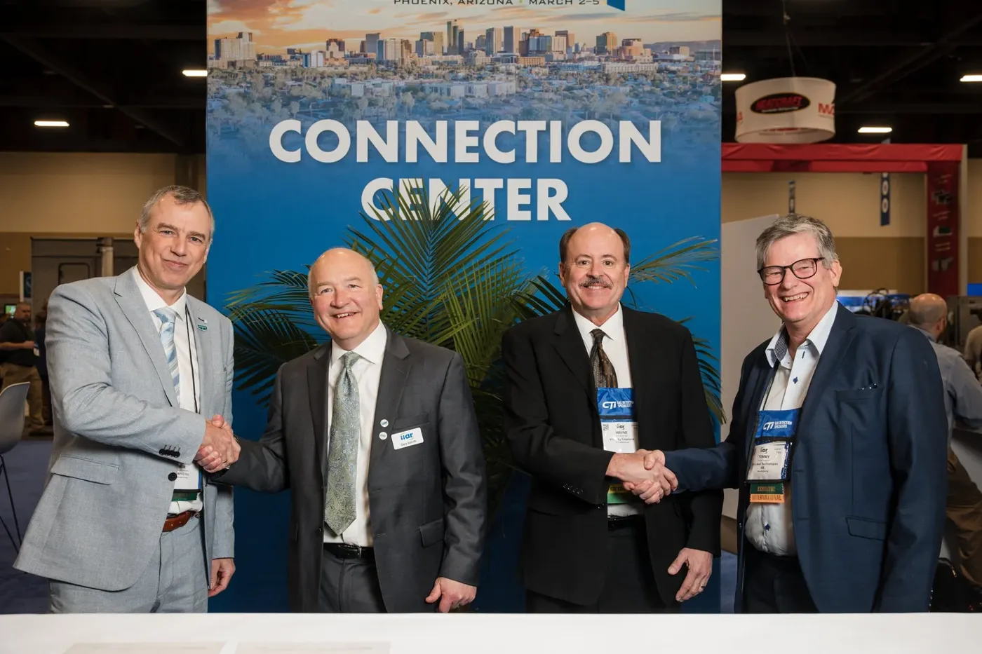 Attendees shaking hands at a conference expo