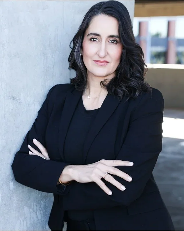 Professional headshot of a woman in a black blazer