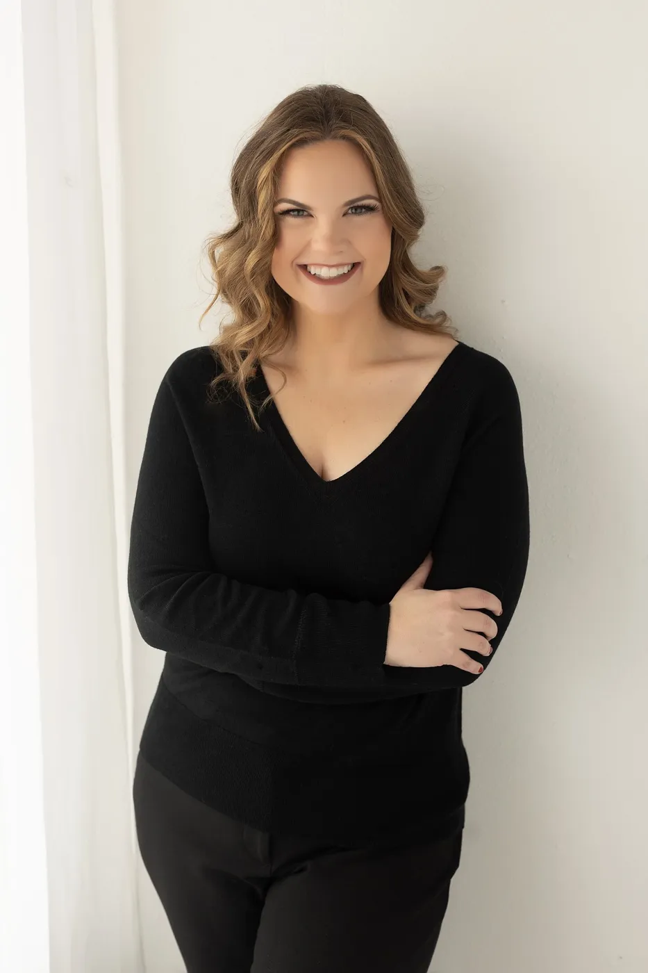 Bright studio headshot of a woman in a black top